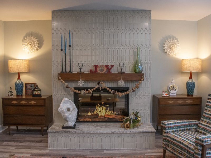 Marla and Tom Norton’s family room features an exotically tiled fireplace among artwork and collections.